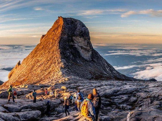 A group of tourists at the peak of Mount Kinabalu