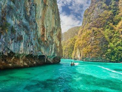 Boat sailing through the cliffs in Phuket