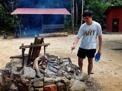 Guy starting a fire in the campsite in Endau Rompin National Park