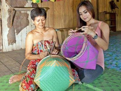 Iban natives in Batang Ai teaching tourists basket weaving
