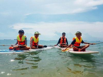 Kids sitting on stand up paddle boards