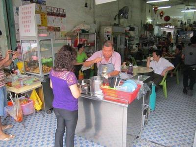 Lady buying food from a hawker in Ipoh