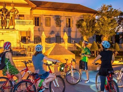 Local guide explaining the history of Chiang Mai city to tourists at Three Kings Monument