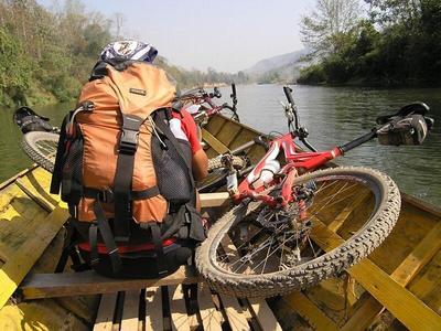 Luang Prabang boat on a river with tourists and bicycle