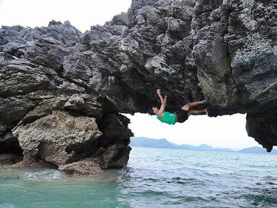 Man climbing up sea cliff in Langkawi