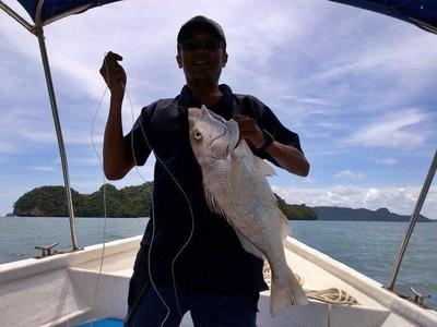 Man holdings his prize from fishing trip at Langkawi
