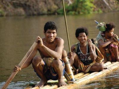 Native Iban tribes riding on a bamboo raft