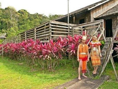 Natives with traditional clothing at stairs to longhouse in Sarawak