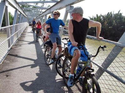 Tourists cycling across a bridge at Nibong Tebal