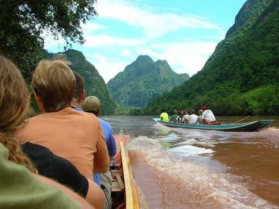 Tourists on longboats cruising along rivers in Nong Khiaw
