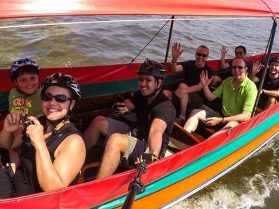 Tourists riding in a boat to explore canals at Bangkok
