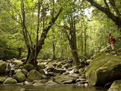 Tourists standing beside a pool of water in Gading National Park