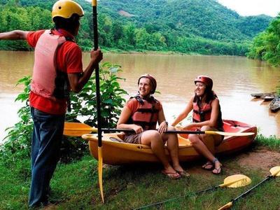 Trainer briefing tourists on kayak by the river in Laos