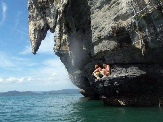 Two women sitting at a rock cliff in Langkawi